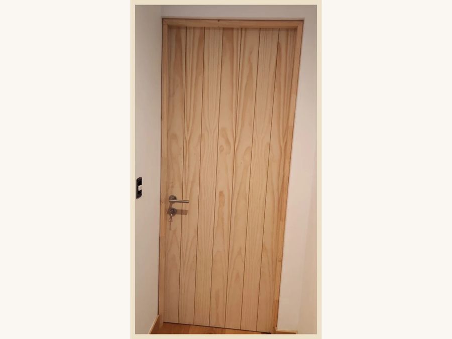 Puerta de abatir MDF enchapada en Pino Radiata con canterías verticales